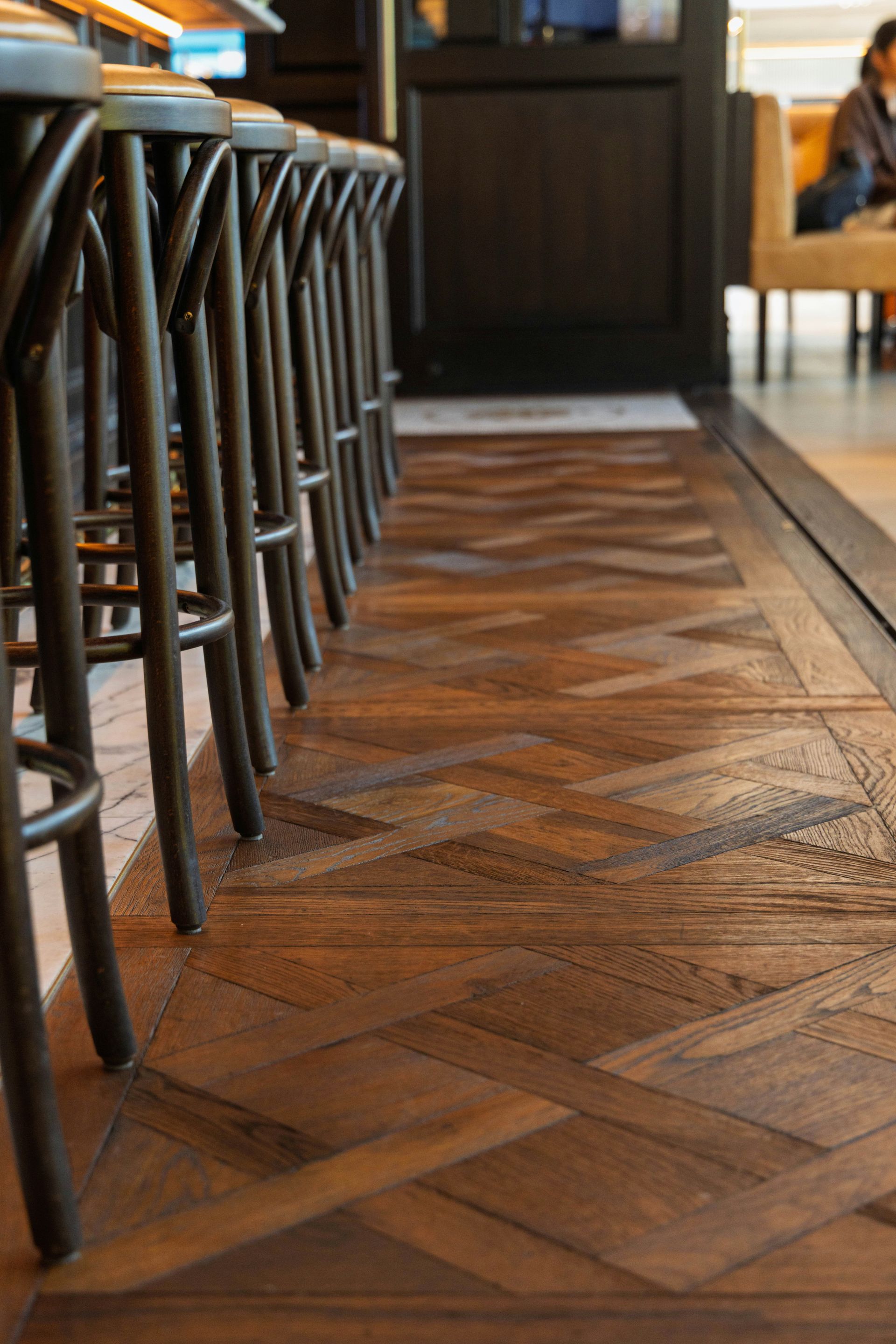 Row of bar stools above patterned wooden floor